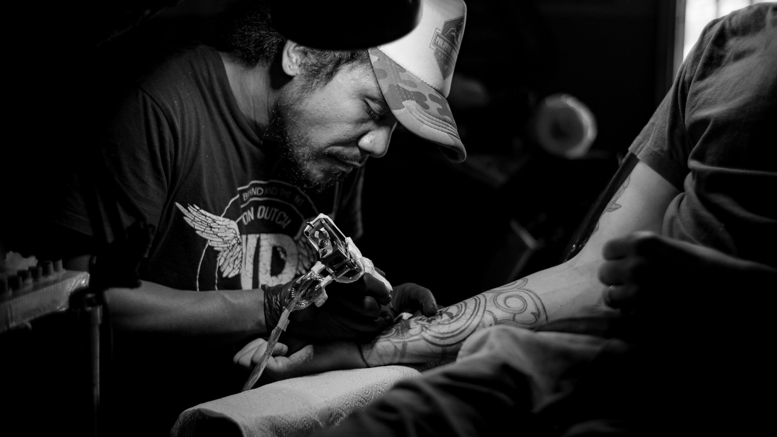 Black and white photo of a tattoo artist at work